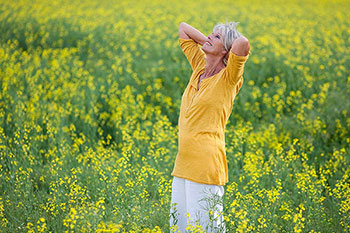 donna senior in un campo di fiori