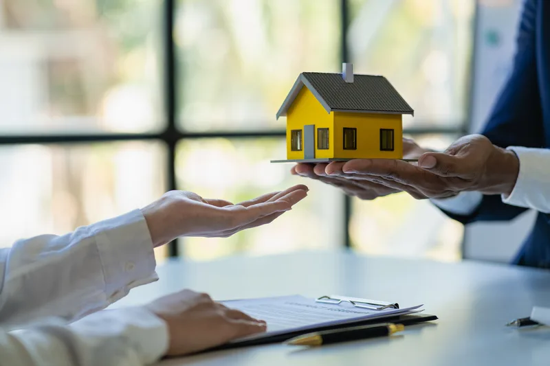 miniatura di una casa che passa da una mano ad un’altra