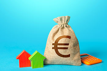 Sacco di denaro contrassegnato dal simbolo dell'Euro con accanto una calcolatrice arancioe e 2 casette di legno colorato, una verde e una rossa, su fondo azzurro.