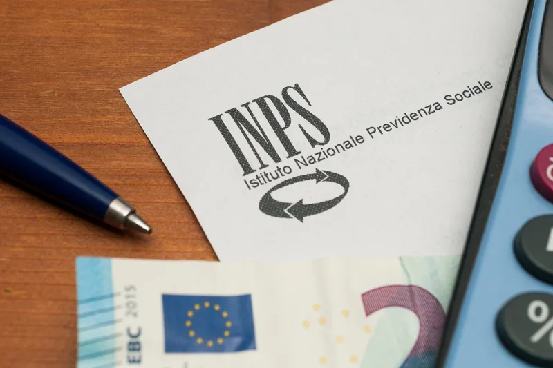 carta intestata inps vicino ad una penna banconota e calcolatrice