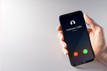 Mano tiene cellulare con chiamata anonima in corso.