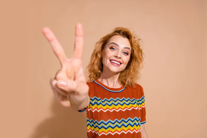 donna che fa il segno della v con la mano