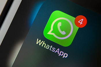 Dettaglio di uno schermo di cellulare con l'icona di Whatsapp e l'indicazione di 4 notifiche.